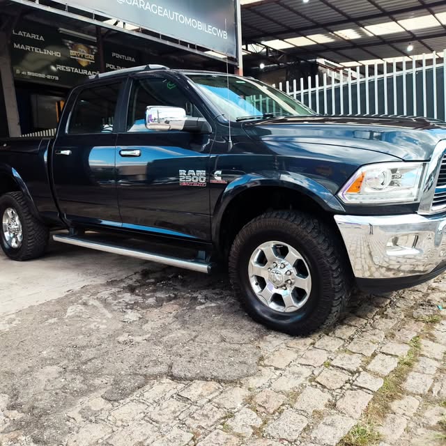 Caminhonete Ram 2500 preta detalhada na frente da oficina